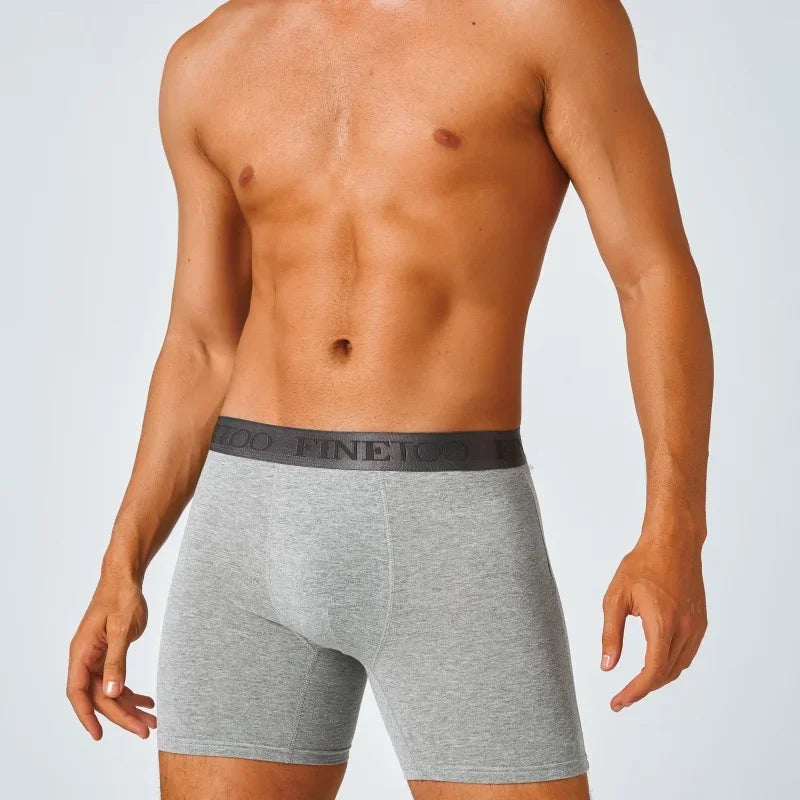 Man wearing gray boxer briefs with a brand logo on a light gray background